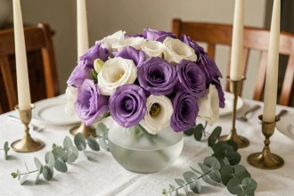 Décoration de table élégante avec lisianthus violet et blanc dans un vase en verre dépoli, entouré de chandeliers en laiton et d'eucalyptus